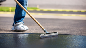 person applying driveway sealer with a squeegee applicator