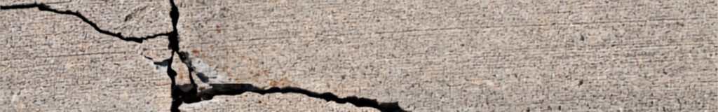 Repairing cracks in a concrete driveway with flexible polyurethane sealant