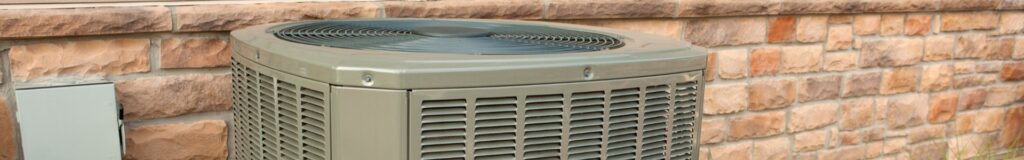 Outdoor central AC condenser unit mounted on concrete pad next to house. How to clean AC condenser unit