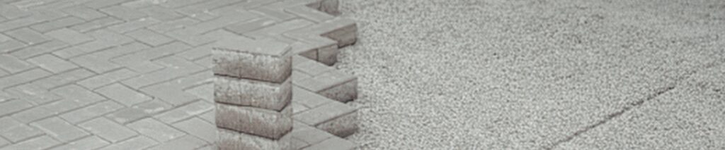 homeowner laying pavers on sand base showing the benefit of how to use a paver calculator for a patio