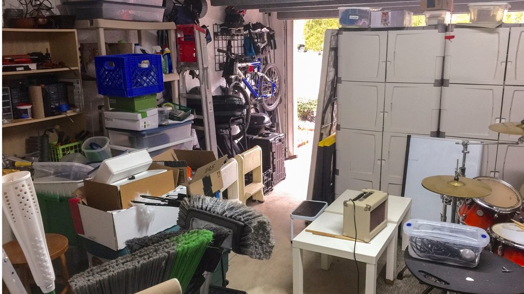 cluttered garage before organizing — items piled on floor with no storage system