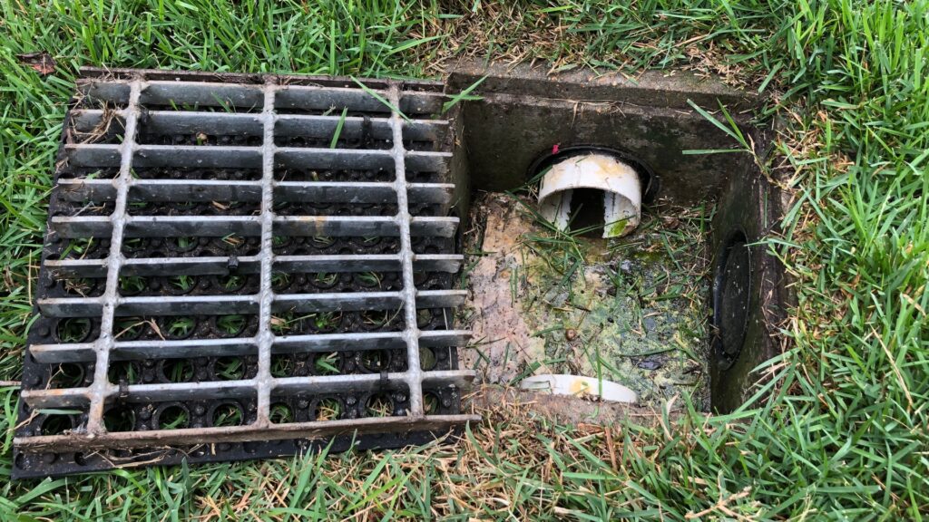 french drain catch basin grate installed in a lawn
