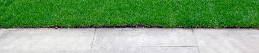 how to edge a lawn — clean grass edge along a concrete sidewalk