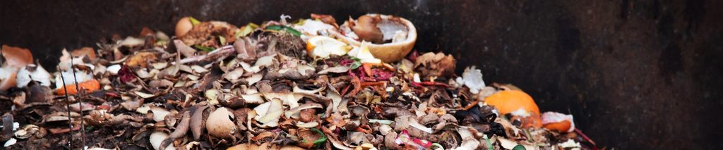 how to start a compost pile — large outdoor compost pile with layered kitchen scraps and organic material