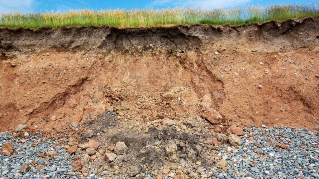 cross section of eroded slope showing topsoil loss and exposed subsoil