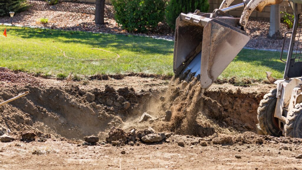 skid steer moving soil during yard grading and excavation