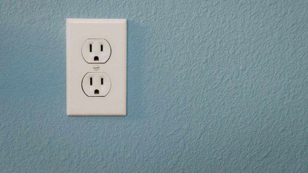standard duplex outlet with no test or reset buttons on a blue wall