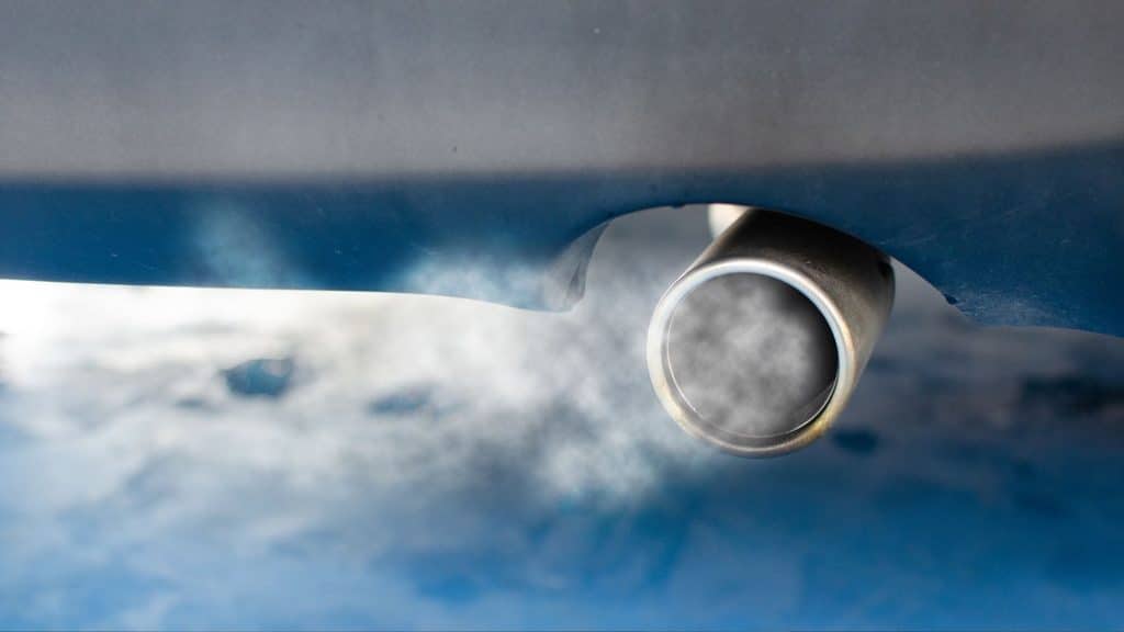 Car exhaust pipe releasing fumes, one of the common sources of carbon monoxide in homes with attached garages