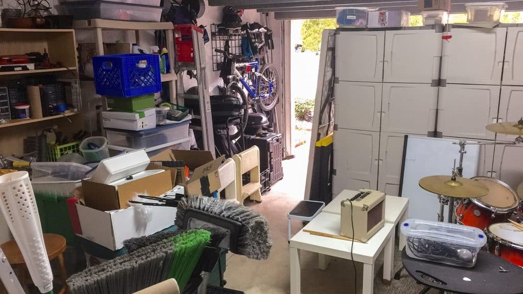 Cluttered garage with boxes and stored items on the floor and against the walls, giving mice places to hide and nest