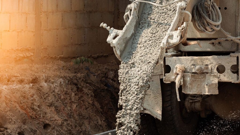 ready-mix concrete truck pouring into a footing form