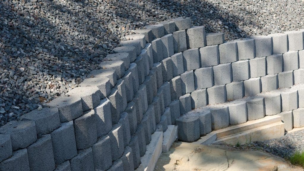 Curved retaining wall blocks with crushed stone drainage gravel filled in behind the wall