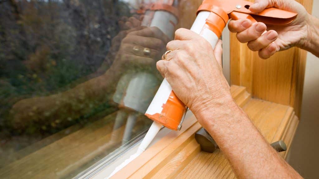 caulking gaps around a window to keep boxelder bugs out