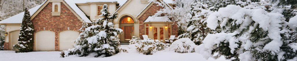 winter home maintenance checklist - suburban house covered in snow